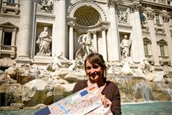 Chica en su viaje de estudios frente de monumento Romano